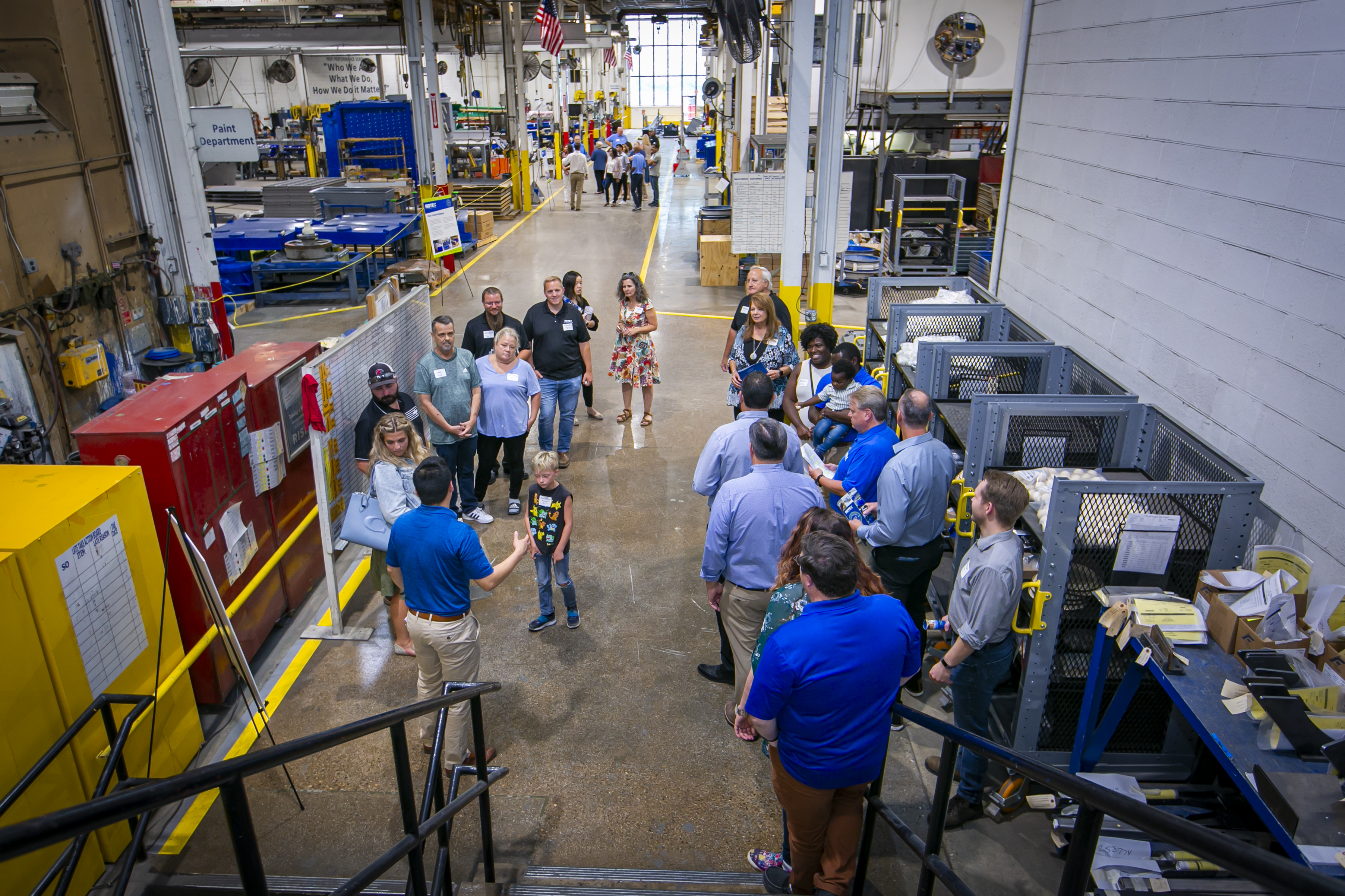 Families and friends of employees taking a tour of the Rotex factory floor.